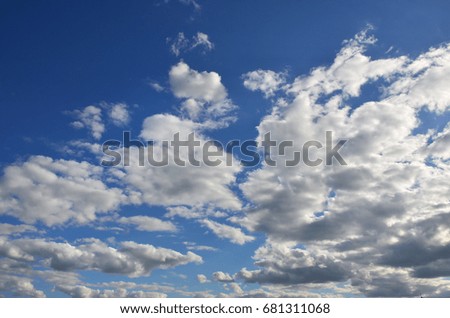 A blue cloudy sky with many small clouds blocking the sun