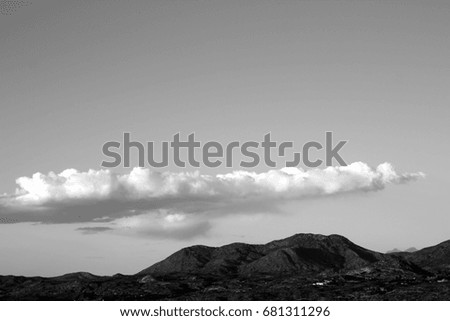 Black and white photo of one huge long monsoon cloud over the Santa Catalina mountains in Tucson Arizona