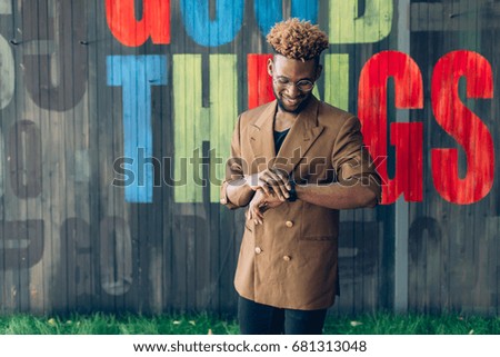 African american man in a jacket near a wooden colored wall