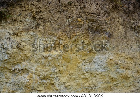 Texture of a wall of solid yellow and brown sand in a sandy quarry