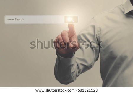 businessman search button on virtual touch screen pressed with finger, vintage soft focus picture concept