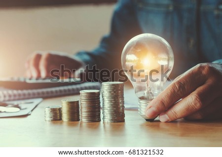 business accounting with saving money with hand holding light bulb concept financial background Royalty-Free Stock Photo #681321532