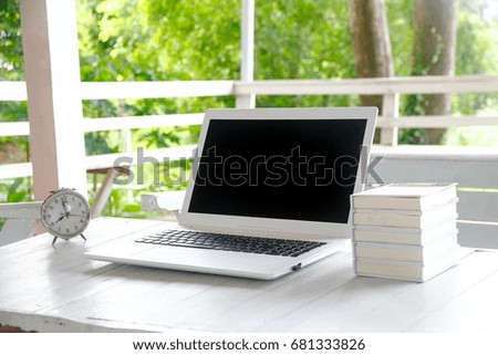 Laptop Empty screen on top of natural wooden table and retro white and wildlife background. For  graphic design display