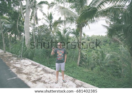 Traveler man with action camera in the tropical jungle of Bali island, Indonesia.