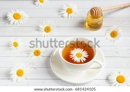 cup of chamomile tea on white wooden background