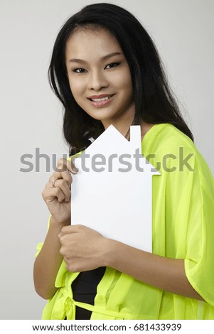 chinese woman holding a house shaped board