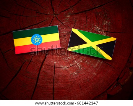 Ethiopian flag with Jamaican flag on a tree stump isolated