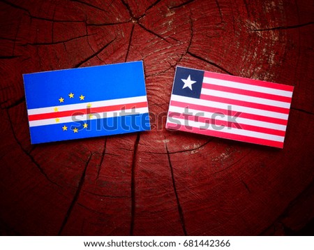Cape Verde flag with Liberian flag on a tree stump isolated