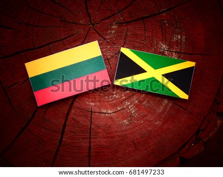 Lithuanian flag with Jamaican flag on a tree stump isolated