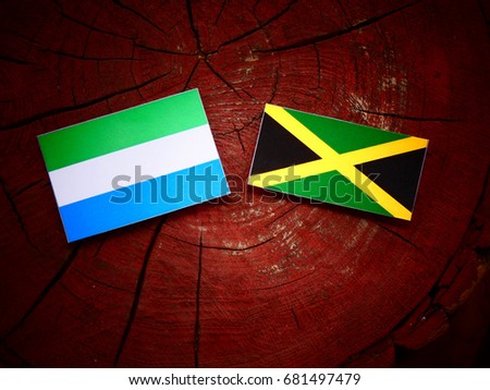Sierra Leone flag with Jamaican flag on a tree stump isolated