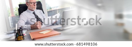 Portrait of mature businessman checking documents in office
