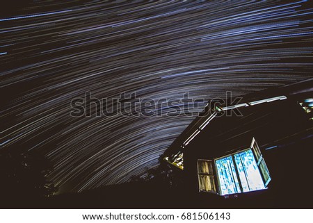 Startrails with little house in the forest