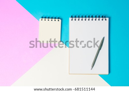 note book paper and pen for note on pink blue and white  background
