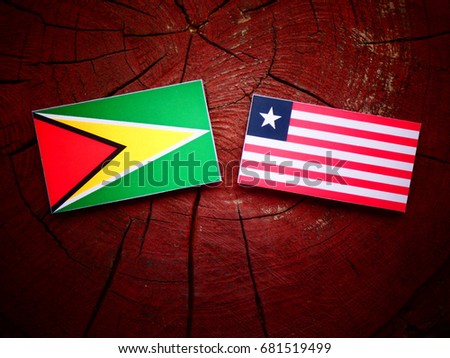 Guyana flag with Liberian flag on a tree stump isolated