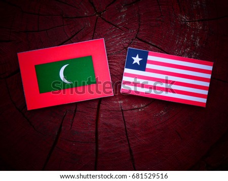 Maldives flag with Liberian flag on a tree stump isolated