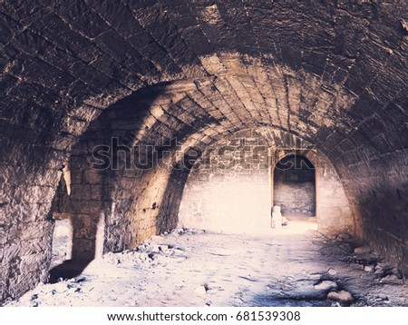 Mystic interior of an ancient dungeon. An old abandoned tunnel in an underground wine cellar. Entrance to catacombs. Dungeon An old stone fortress. As creative background for staging dark design.