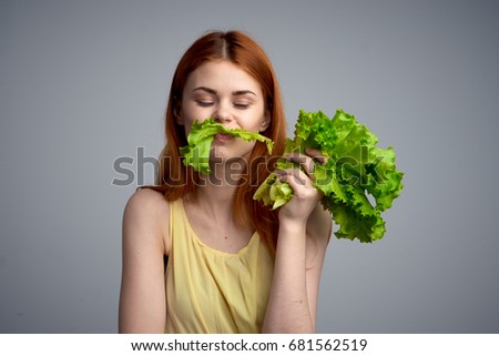 Woman with a lettuce leaf eating the right diet, a slender figure                               