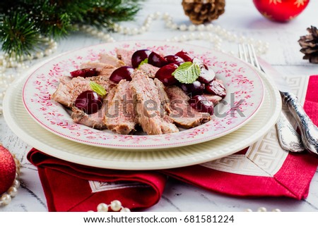 Christmas duck breast with caramelized cherry and red sauce. Holidays dinner concept