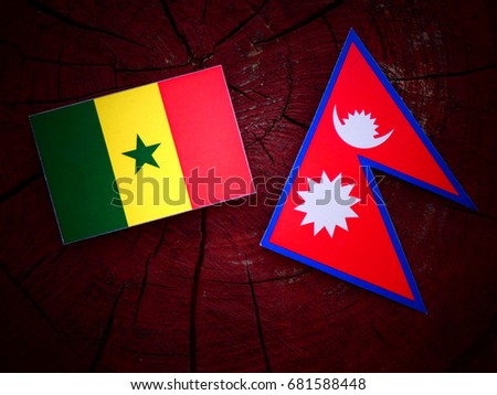 Senegal flag with Nepali flag on a tree stump isolated