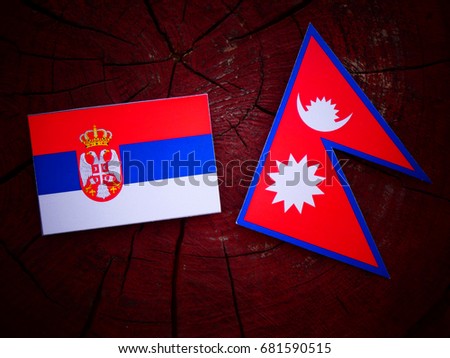 Serbian flag with Nepali flag on a tree stump isolated