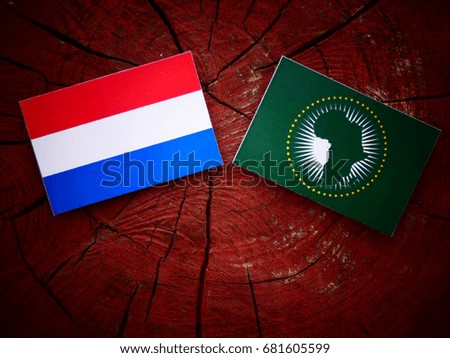 Dutch flag with African Union flag on a tree stump isolated