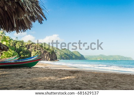 Caribbean beach landscape with the mountains in the background, small and colorful boats stranded in the sand. Medina Beach, Venezuela