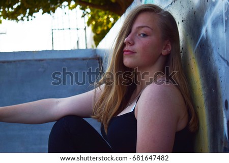 Blonde teenage girl against graffiti wall portrait 