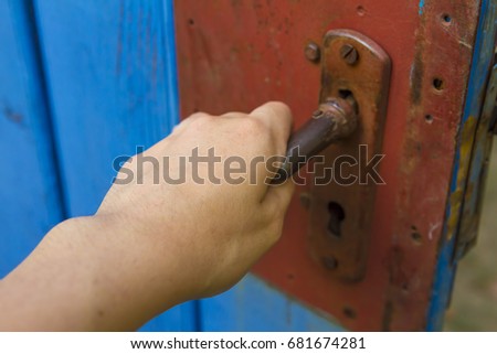 Young woman hand open old wooden door.