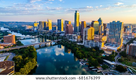 Austin Texas USA sunrise skyline cityscape over Town Lake or Lady Bird Lake with amazing reflection. Skyscrapers and Texas capital building in distance you can see the entire city during summer Royalty-Free Stock Photo #681676399