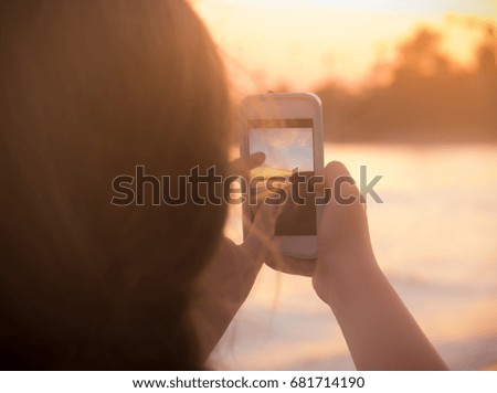 Girl Takes Sunset Beach Phone Photo