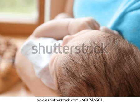 Cute baby boy with mother at home, closeup