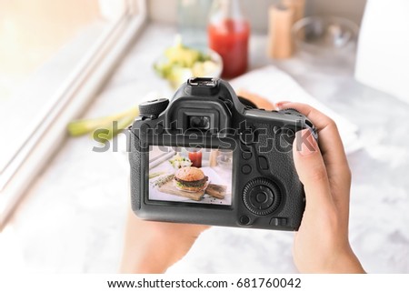 Woman taking photo of fast food with professional camera