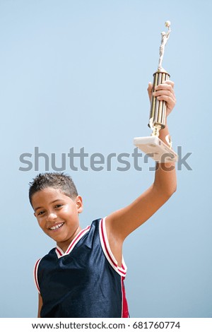 Boy holding up basketball trophy