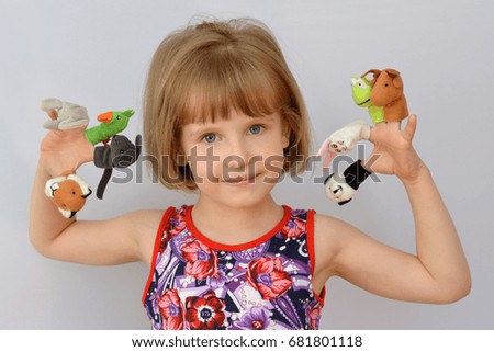  child, kid,(little girl) playing  with dolls is wearing on the fingers