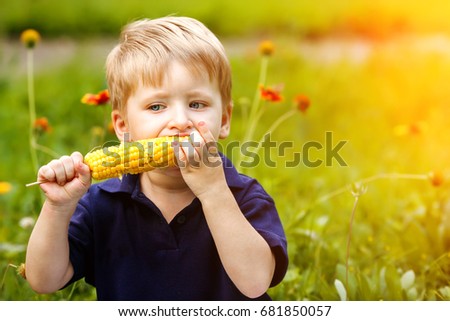 Young boy eating corn on the cob