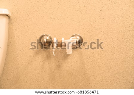 Close-up of finished toilet paper roll in bathroom. Empty roll on toilet paper holder with white wall background. Empty toilet paper roll in restroom. Out of toilet paper dilemma concept