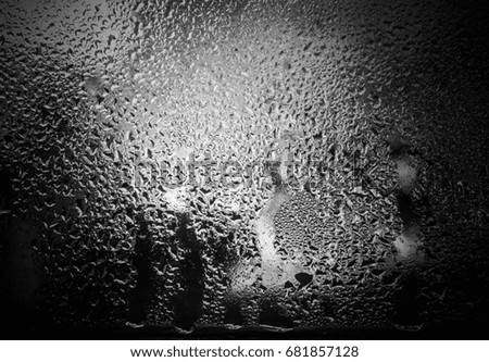 A close-up photograph of hot water vapor condensed on a cold glass window with a dark vignette border. This photo was taken in Brisbane, Australia. 