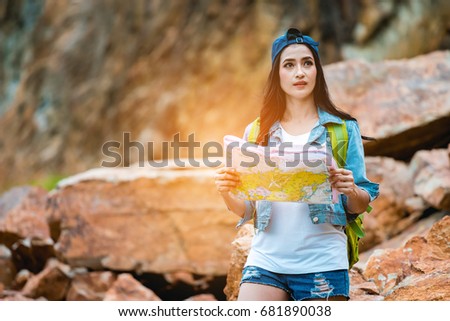 Hipster young girl with backpack enjoying the adventure and looking the map.