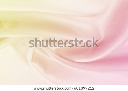 Background pattern, texture. Silk fabric yellow pink pastel tones. Silk background in pink and yellow colors. 