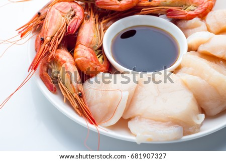 Scallop, shrimp, sauce on a white plate on a white background closeup
