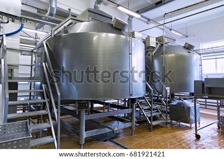 Industrial dairy production. Storage steel tanks on the milk factory. Royalty-Free Stock Photo #681921421