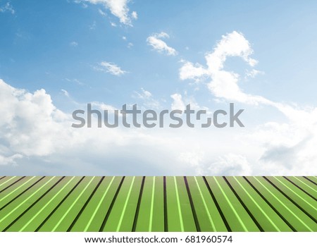Green flooring against the sky with clouds