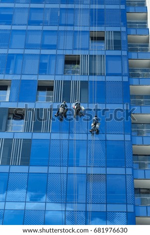 Workers are cleaning the windows of skyscraper