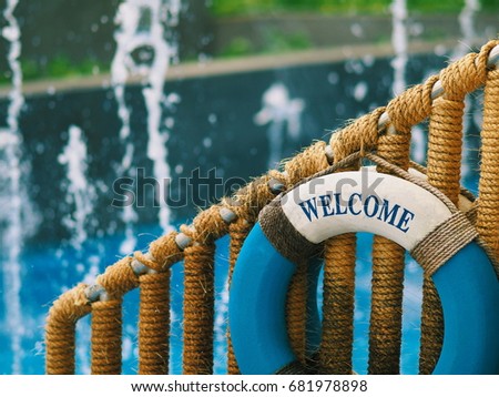 Blue Life ring hanging on the Railing on fountain background in waterpark. Survival kit gear. Safety concept