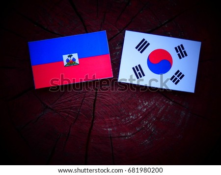 Haitian flag with South Korean flag on a tree stump isolated