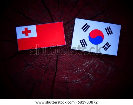 Tongan flag with South Korean flag on a tree stump isolated