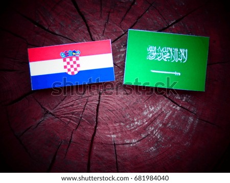 Croatian flag with Saudi Arabian flag on a tree stump isolated