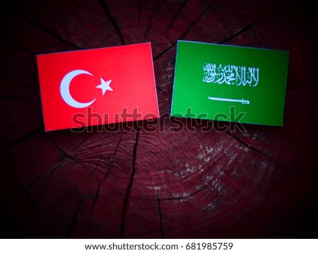 Turkish flag with Saudi Arabian flag on a tree stump isolated