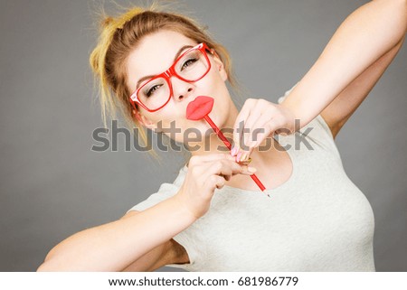 Happy woman holding fake lips on stick having fun. Photo and carnival funny accessories concept.