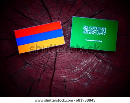Armenian flag with Saudi Arabian flag on a tree stump isolated